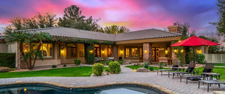 Luxury home in the East Valley with a resort-style backyard, pool, and outdoor entertaining space at sunset